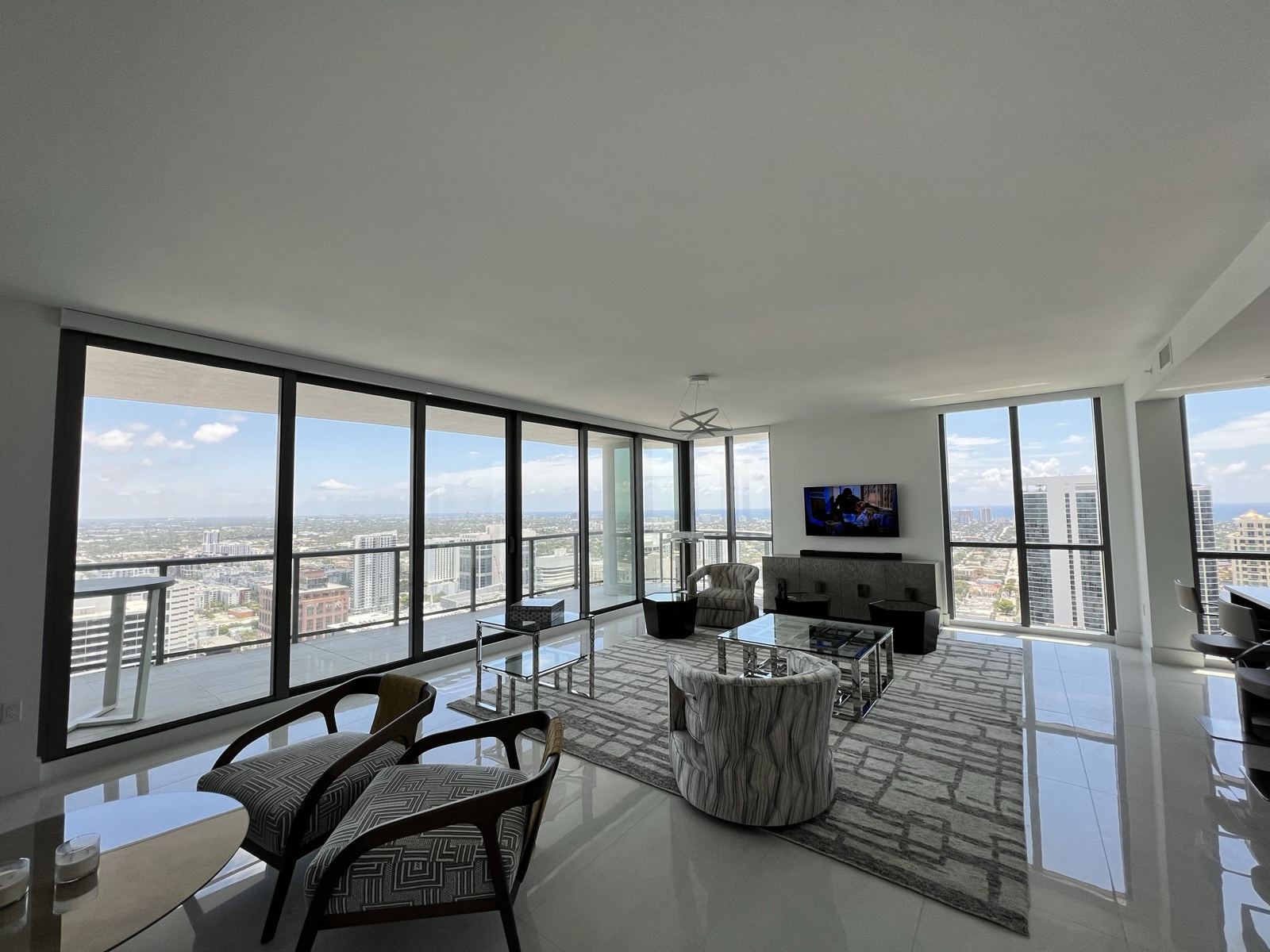 Corner living room with bare floor-to-ceiling windows